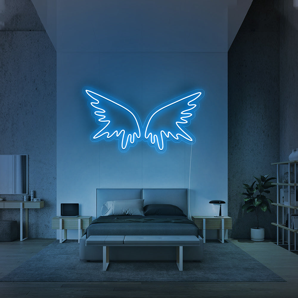 Ijsblauw LED-sign in de vorm van vleugels aan een strakke slaapkamermuur