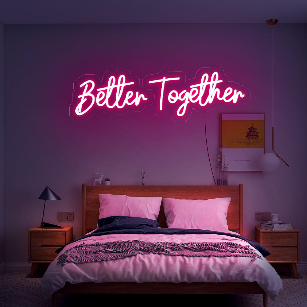 Roze handgeschreven Better Together LED-verlichting aan de wand in een romantische slaapkamer
