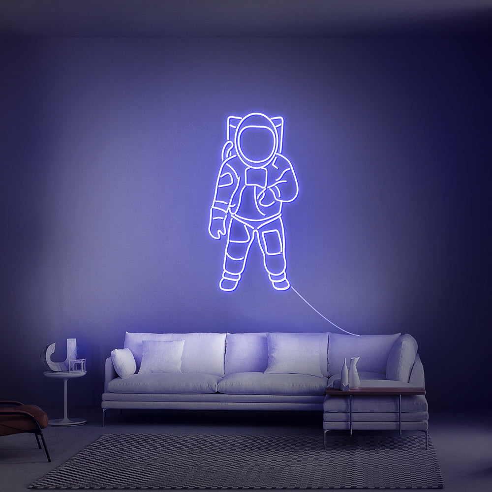 Donkerblauw verlicht ruimtevaarder-silhouet als sfeervolle wanddecoratie boven een bed