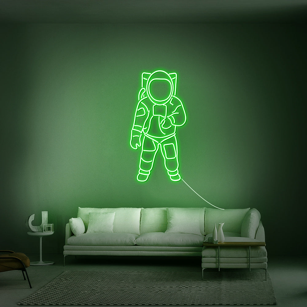Gedetailleerd LED-sign van een kosmonaut in de kleur groen met een felle glow in een game room