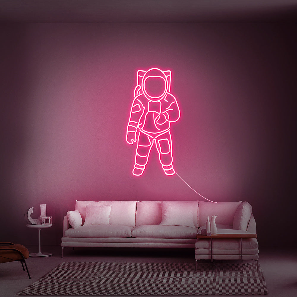 Roze LED-wandverlichting in de vorm van een astronaut in een trendy tienerkamer